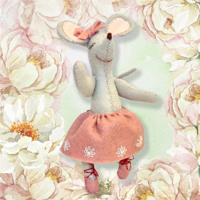 Stuffed mouse toy in a pink dress on a floral background
