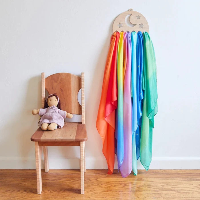 Star-shaped silk display hanging on a wall next to a chair with a doll.