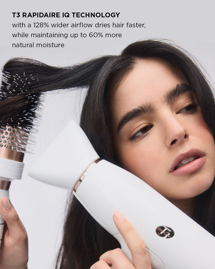 Woman using a white hair dryer with a brush attachment, featuring T3 branding.