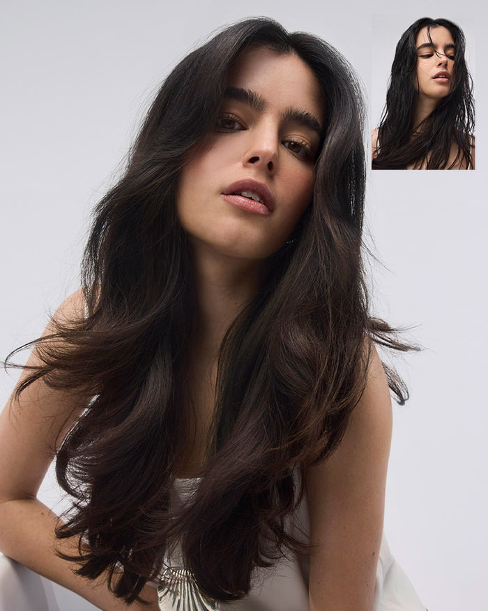 Woman with long dark hair against a white background