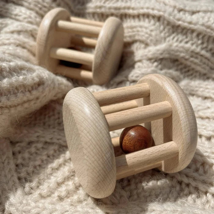 Wooden baby rattles on a soft fabric background