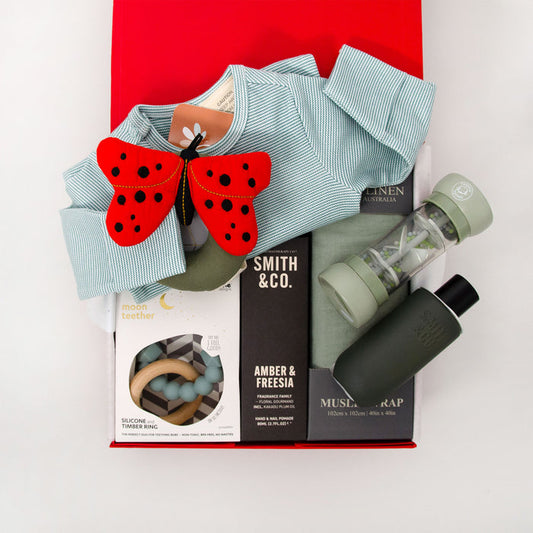Collection of baby products including a long sleeve romper, ladybird-shaped rattle, teether, muslin wrap hand cream and room spray. $195.00