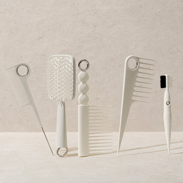 Set of white hair care tools on a stone surface with a neutral background