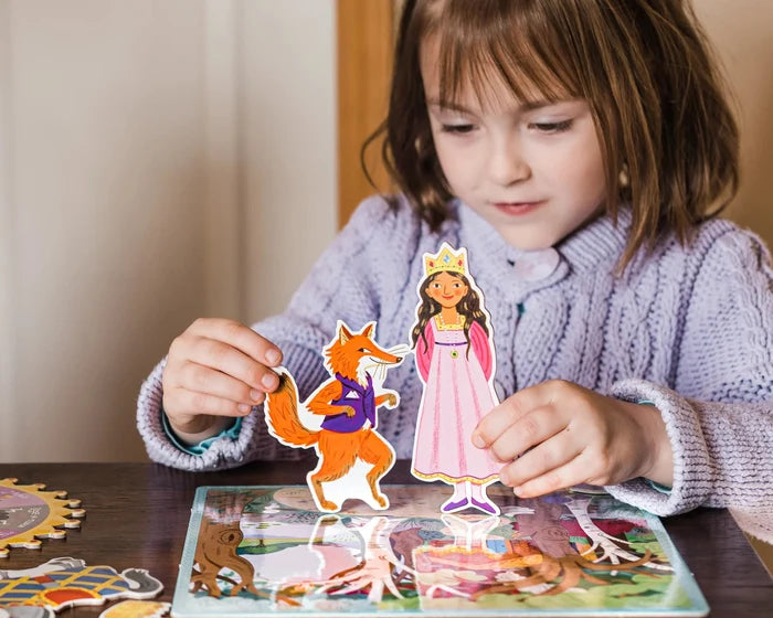 Child playing with a princess and fox paper cutout on a table