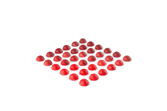 Wooden half spheres in various shades of red on a white background