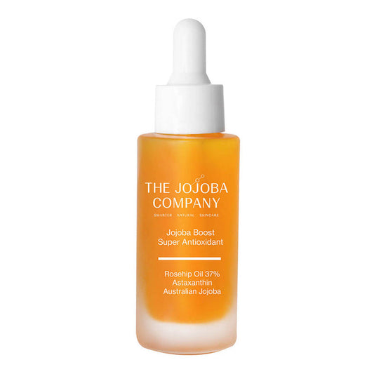 Orange skincare serum bottle with dropper labeled 'The Jojoba Company' on a white background.