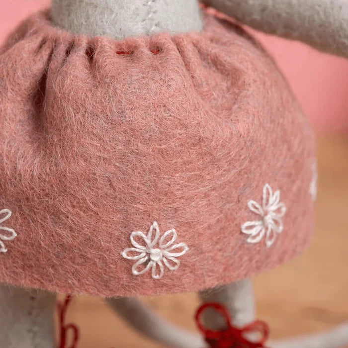 Close-up of a pink skirt with white floral patterns on a blurred background