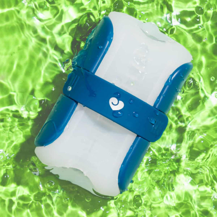 Blue and white silicone personal stroker in water against green background.