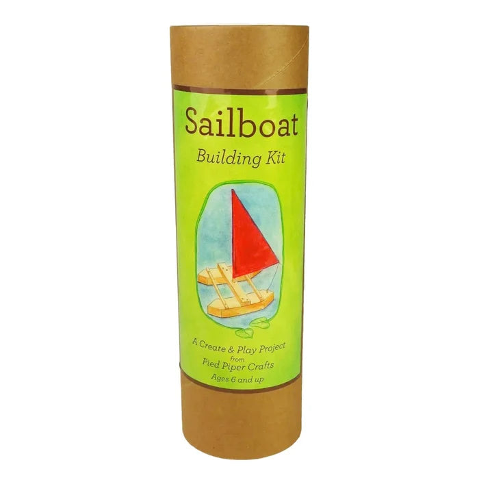 Sailboat building kit packaging with green label and brown cardboard tube on a white background