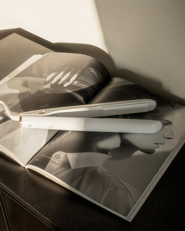 Hair straightener on an open magazine with a blurred background