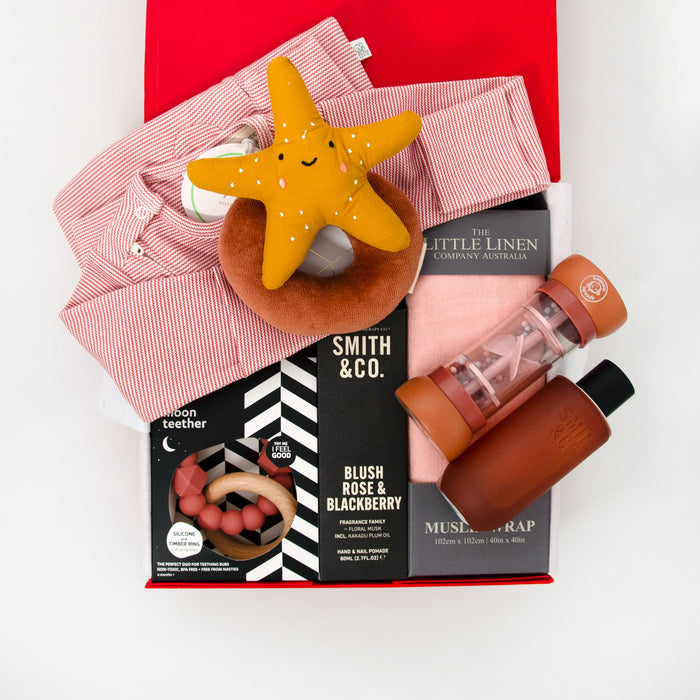 Collection of baby products including a long sleeve romper, star-shaped rattle, teether, muslin wrap hand cream and room spray. $195.00