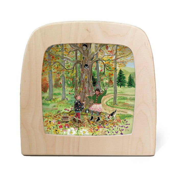 Wooden frame with a scene of children and a dog in a forest.