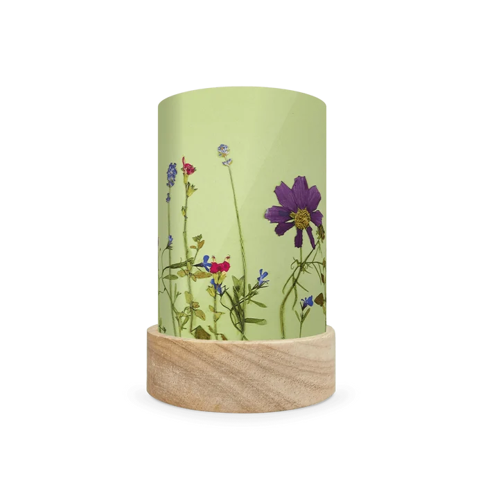 Mini lantern silhouette of pressed blue, purple, and red flowers on a light green background