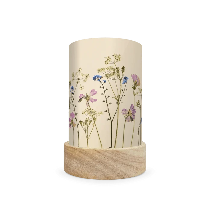 Mini lantern silhouette of pressed pink and blue flowers and bright green leaves on a light background