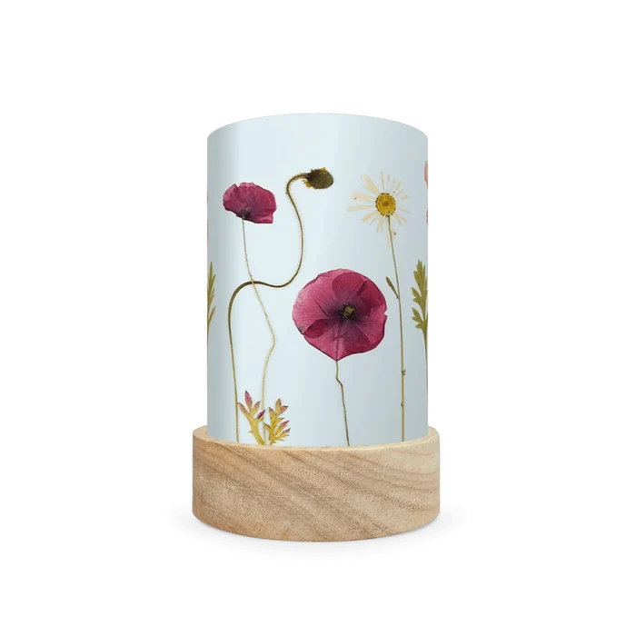 Mini lantern silhouette of pressed purple and white flowers on a light blue background