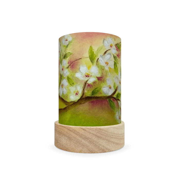 Decorative cylindrical lamp featuring white spring flowers