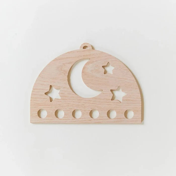 Wooden silk display with star and moon cutouts on a white background